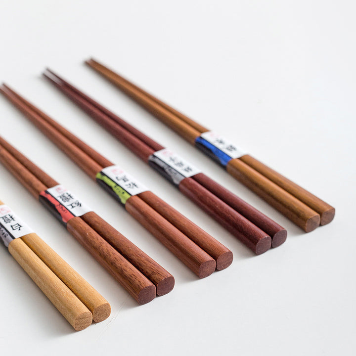 A close-up image highlighting the fine grain and texture differences between the Japanese hop-hornbeam, bamboo iris, pine, red sandalwood, and white sandalwood chopsticks.