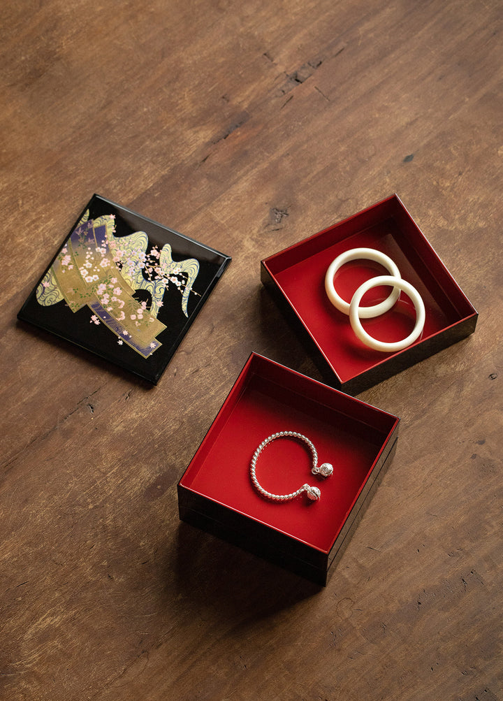 This image shows the jewelry box in use, filled with various pieces of jewelry. The red interior provides a striking backdrop for the stored items, showcasing how the box can elegantly display and organize your treasures. The sturdy construction and smooth lacquer finish are evident, emphasizing both its functionality and beauty.
