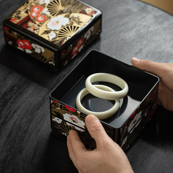 This image depicts the jewelry boxes in use, filled with a pair of jade bangles. The black interior offers a sophisticated backdrop.