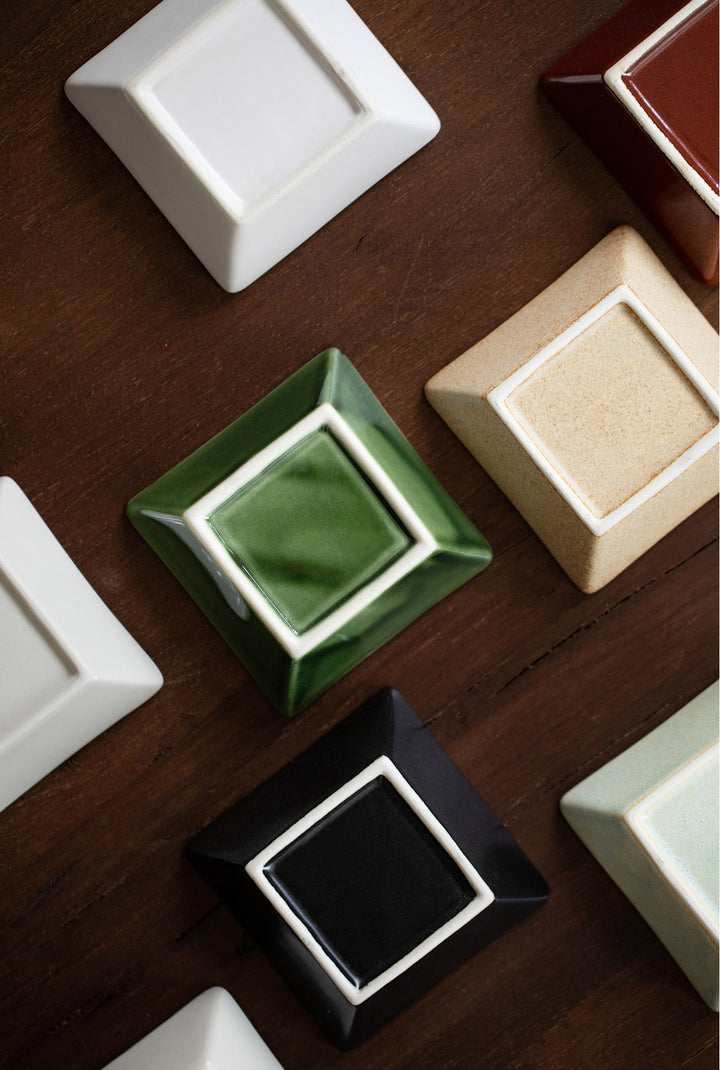 A photograph highlighting the bottoms of the plates, revealing the artisanship and craftsmanship in the design and texture of the ceramic, emphasizing the quality and attention to detail.