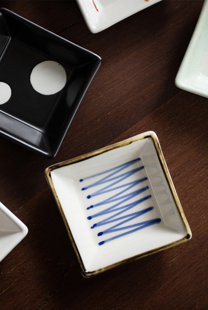 An image zoomed in on the plate with blue zigzag lines on a white background, showing the delicate brushstrokes and the plate’s texture.