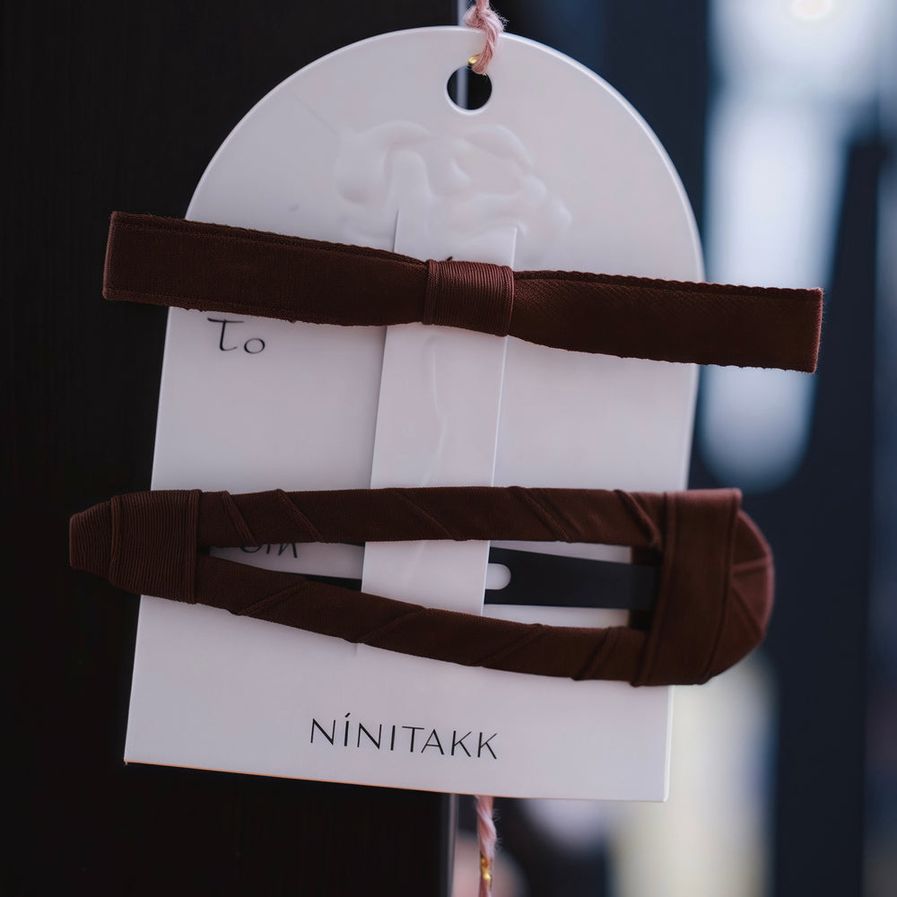 This set features a rich brown fabric barrette clip and a coordinated brown alligator clip with a slim bow, offering a warm and sophisticated accessory that seamlessly integrates into your wardrobe.