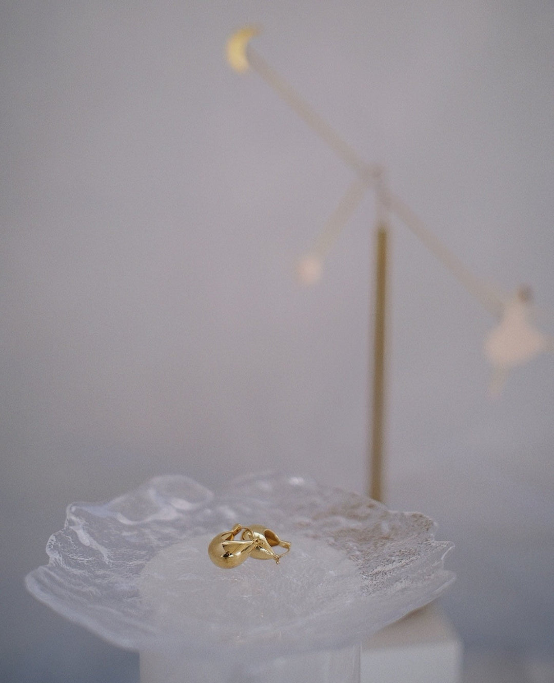 The gold-plated sterling silver vessel earrings displayed on a clean surface, showcasing their shiny finish and chunky design.