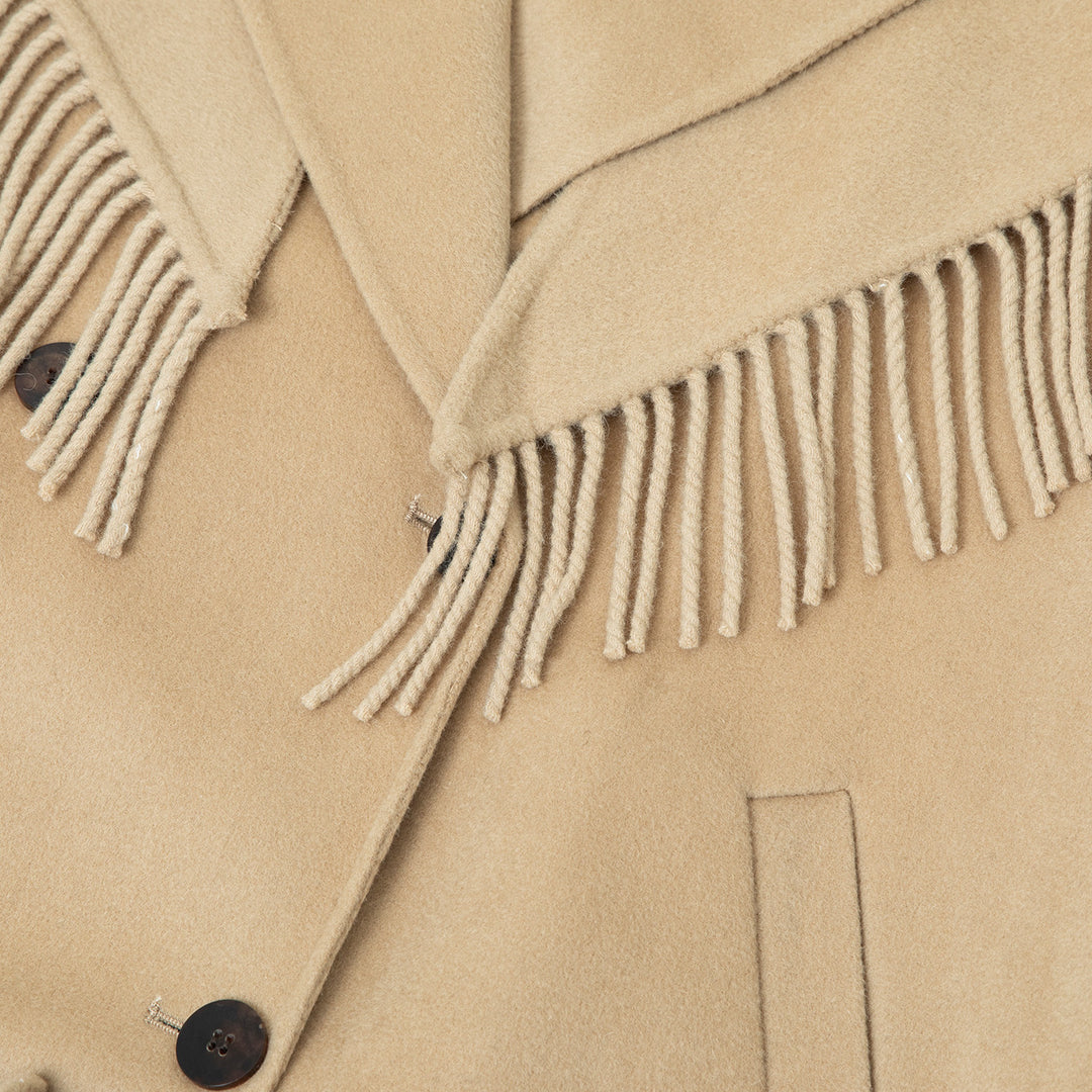 Close-up view of the fringe scarf, highlighting its intricate details and luxurious wool texture.