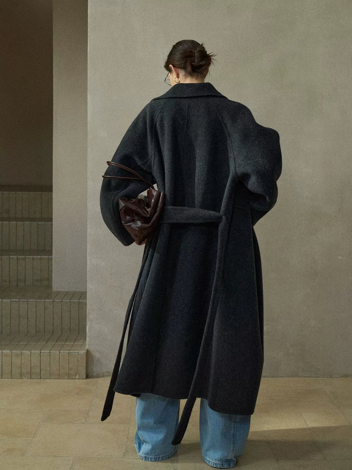 Back view of charcoal grey wool coat showing full length, oversized fit, and tie belt detail
