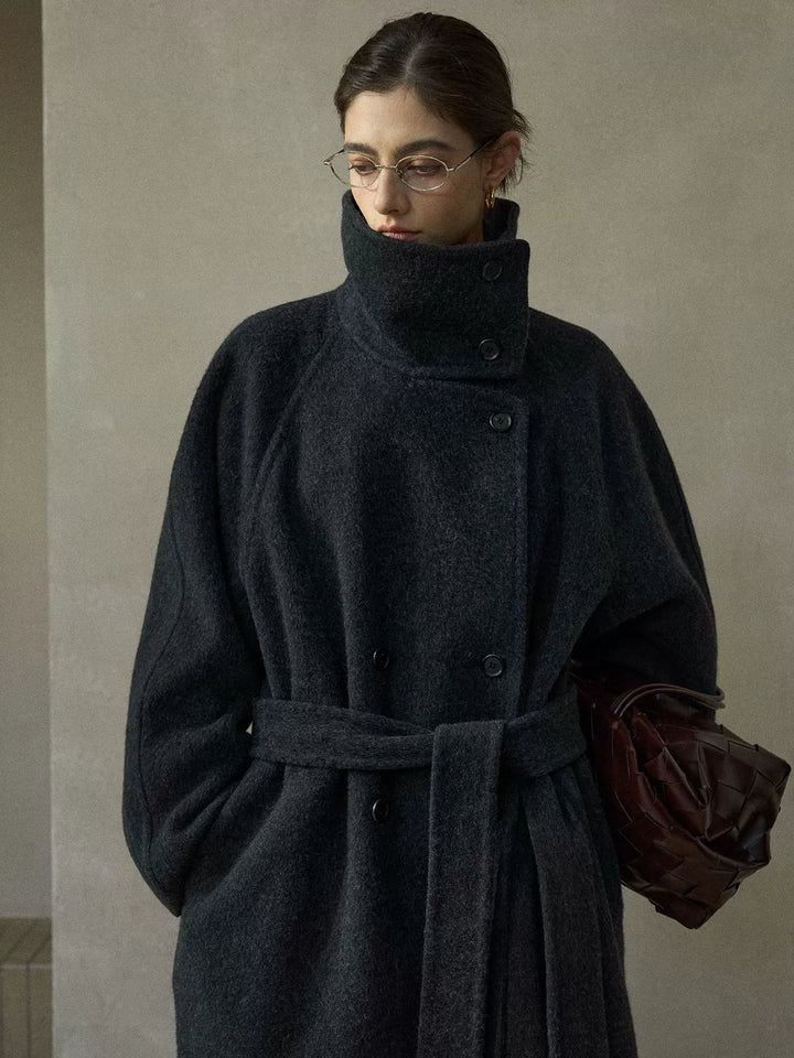 Close-up of charcoal grey coat's collar, button closure, and structured tailoring